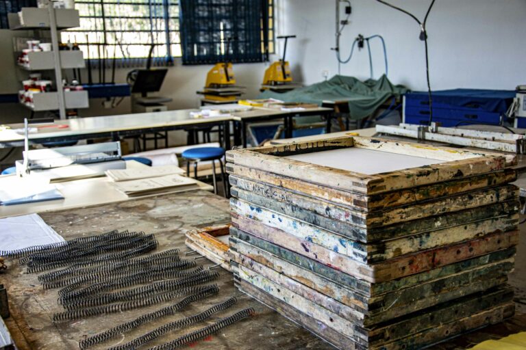 Interior of a textile workshop in Apucarana, highlighting screen printing frames and equipment.